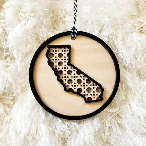 There is nothing like Home for the Holidays!  Whether you have just moved to a new state, bought a new home or know someone who did...   A little something for your own Christmas tree perhaps...  A delicate Rattan design in the outline of your home state.  Each ornament measures approximately 3.9 inches and is made of combination of natural birch wood and black board. California State Rattan Ornament