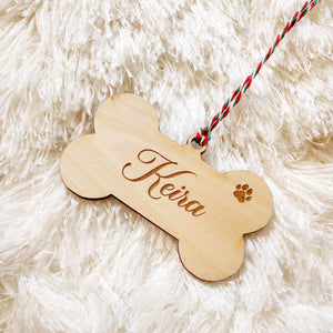 Christmas Ornament made in the style of dog bone. Engraved with the name of your favorite four-legged friend and a paw print. Makes a great gift for all pet lovers.