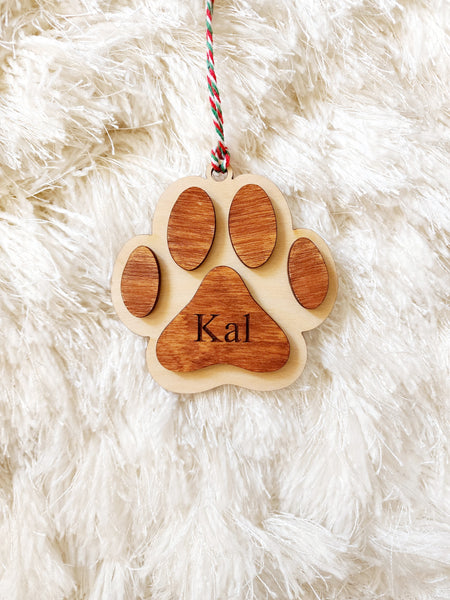 Christmas ornament made with wood in the style of a paw. The ornament is 3D design - 2 layers make up the design with the name engraved in the middle. 