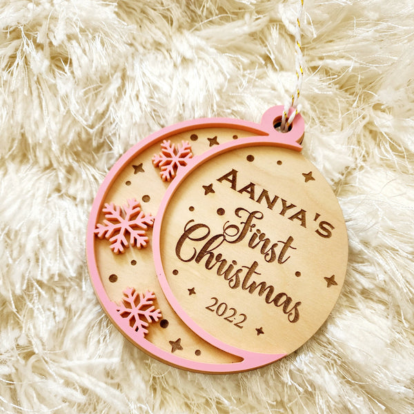 Baby's First Christmas Ornament A milestone as special as your new bundle of joy. A personalized ornament for the baby with his/her name engraved on birch wood. Each ornament is a 2 layer ornament. The second layer can be white, pink or blue - as you choose in the section below. The design is stars and snowflakes cut and engraved into this beautiful piece.Approximate size of each ornament : 3.5 inches
