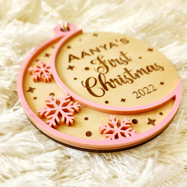 Baby's First Christmas Ornament A milestone as special as your new bundle of joy. A personalized ornament for the baby with his/her name engraved on birch wood. Each ornament is a 2 layer ornament. The second layer can be white, pink or blue - as you choose in the section below. The design is stars and snowflakes cut and engraved into this beautiful piece.Approximate size of each ornament : 3.5 inches